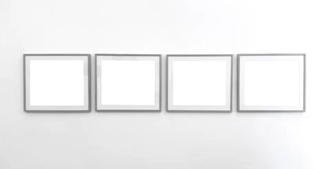 Four empty picture frames arranged on wall. Minimal square borders forming Stock Photos