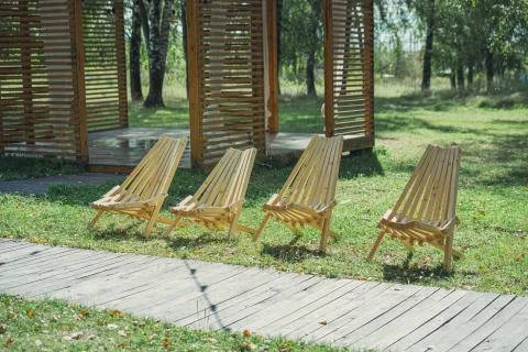Four empty wooden deck chairs in the garden Stock Photos