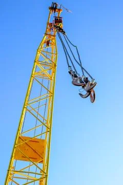 Four empty yellow crane hook hanging down isolated on white background Foto stock