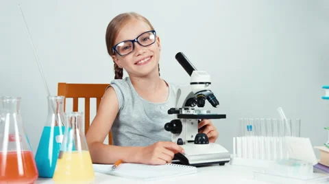 Four-eyes tries to use a microscope and smiling Stock Footage 65452397