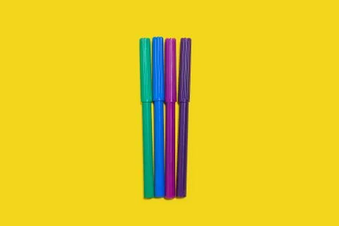 Four felt pens on a yellow surface Stock Photos