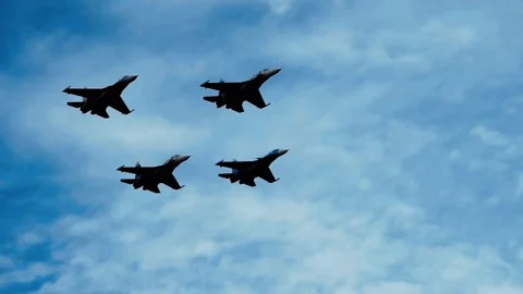 Four fighter jets flying in formation through blue sky and clouds Stock Footage 332874126