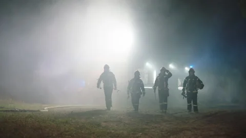 Four Firefighters doing their job at night Stock Footage 283139577