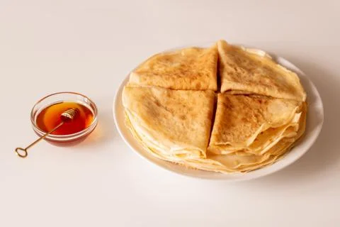 Four folded appetizing pancakes on stack of others on white porcelain plate Stockfoto's