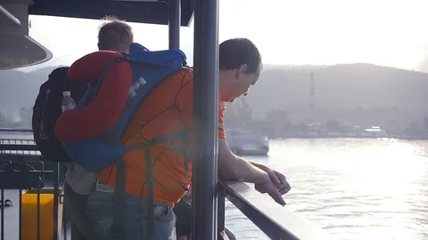 Four friends with backpacks stand on the deck of the ferry and approach the Stock Footage 88800548
