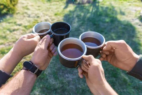Four friends drinks tea while camping. Stock-Fotos