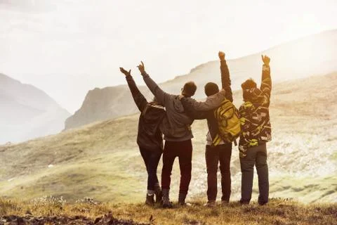 Four friends having fun mountain sunset Stock Photos