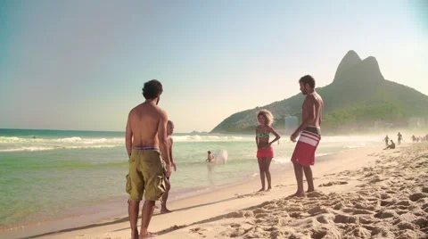 Four friends playing football on Ipanema beach Stock Footage 59376841