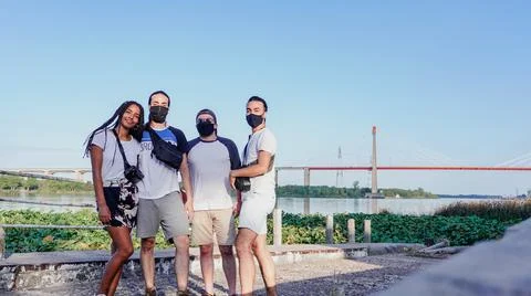 Four friends posing in front of the bridge Stock Photos