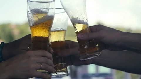 Four friends raise glasses with a refreshing beer up, drink for health. slow Stock Footage 86891443