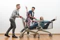 The four friends ride on the cart on a white wall background Photo