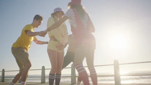 Four Friends rollerskating on the broadwalk and playing Stock Footage 279342479