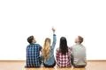 The four friends sit on the floor and gesture on a white wall background Photo