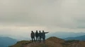 The four friends standing on a foggy mountain top 4k or 4k+ Resolution