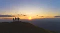The four friends standing on the mountain against a beautiful sunrise 4k or 4k+ Resolution