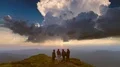 The four friends standing on the mountain against a sunset 4k or 4k+ Resolution