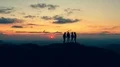 The four friends standing on a mountain with the beautiful sunset 4k or 4k+ Resolution