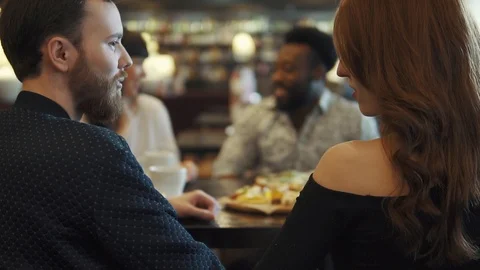 Four friends at a table in a cafe or restaurant. friends spend time together Stock Footage 91088188