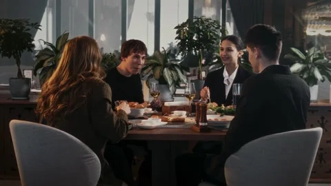 Four friends at a table in a restaurant with an expensive, beautiful interior Stock-Footage 315231985