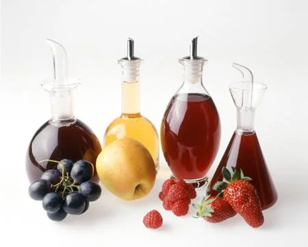 Four fruit vinegars Stock Photos