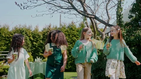 Four girls drinking walking at the backyard party on a sunny day Stock Footage 197876827