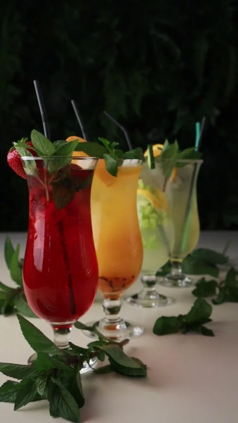 Four Glasses with Different Juice Made of Strawberry, Orange, Mint and Lemon Stock Footage 241324304