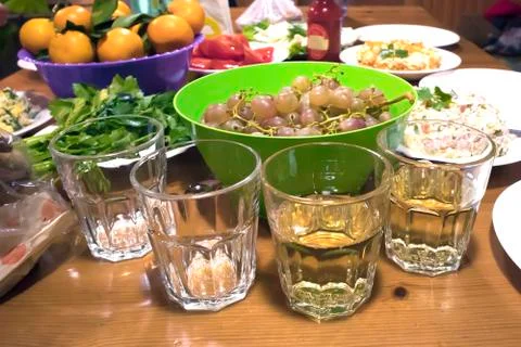 Four glasses on a rustic party table closeup Stock Photos