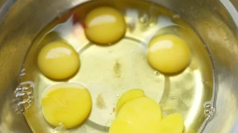 Four glossy yellow egg yolks poaching in shallow Stock Footage 330336067