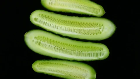 Four half sliced cucumbers rotate over black background. 4K 動画素材 74060364
