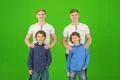 The four happy brothers stand on the green background Photo