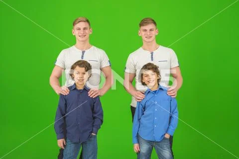 The four happy brothers stand on the green background Stock Photos