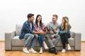 The four happy friends with bottles of beer sit on a white wall background Photo
