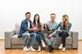 The four happy friends with bottles of beer sit on a white wall background Photo