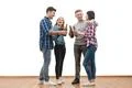 The four happy friends drink a beer on a white wall background Photo