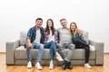 The four happy friends sit on the sofa on a white wall background Photo