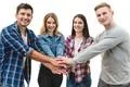 The four happy people hold hands together on the white background Photo