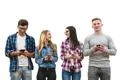 The four happy people with phones stand on the white wall background Photo