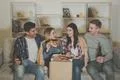 The four happy people with a pizza and a beer watch a movie on the sofa Photo