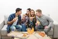 The four happy people on the sofa eat pizza on the white background Photo