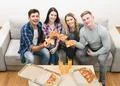 The four happy people on the sofa eating pizza Photo