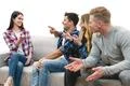 The four happy people on the sofa play the game on the white background Photo
