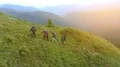 The four hikers with backpacks walking up on the mountain 4k or 4k+ Resolution