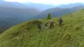 The four hikers with backpacks walking up on a mountain 4k or 4k+ Resolution