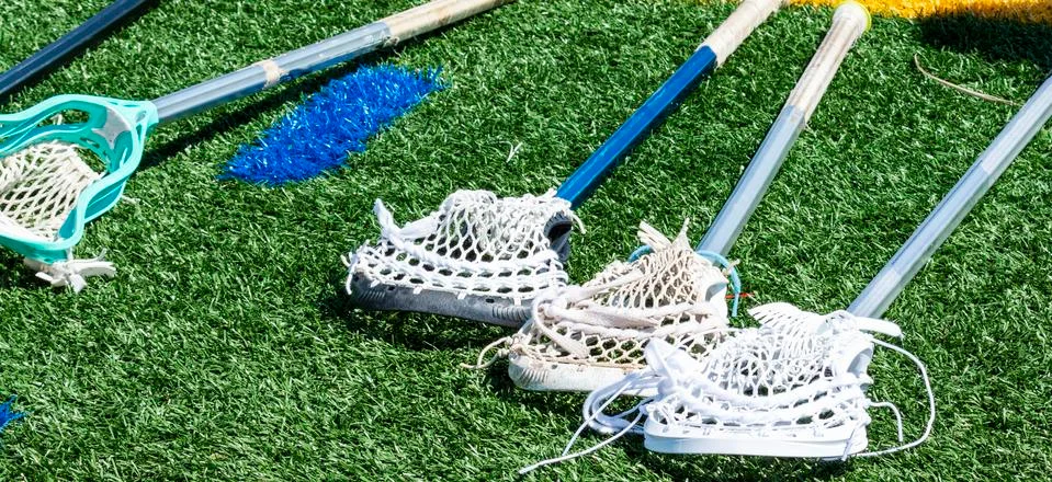 Four lacrosse sticks laying on the turf Stock Photos