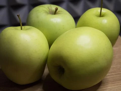 Four large apples, close-up. Fruit on a wooden surface. Stock Photos
