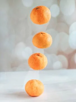 Four levitating tangerines on a beige background. The concept of a healthy li Stock Photos