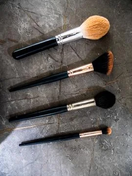 Four Makeup Brushes Arranged On A Dark Surface Stock Photos