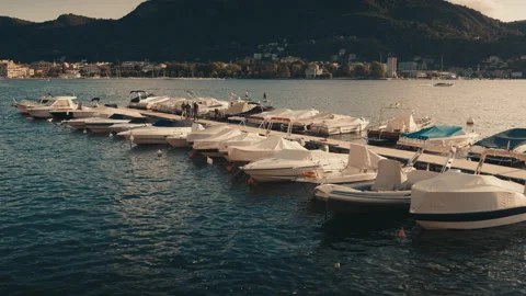 Four man talking on a pontoon on the Como Lake with boat floating around them Video stock 139272028