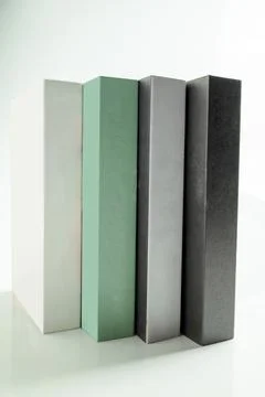 Four minimalist decorative books in white, mint green, grey, and black stan.. Stock Photos