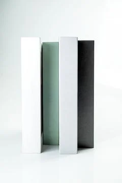Four minimalist decorative books in white, mint green, grey, and black stan.. Stock Photos